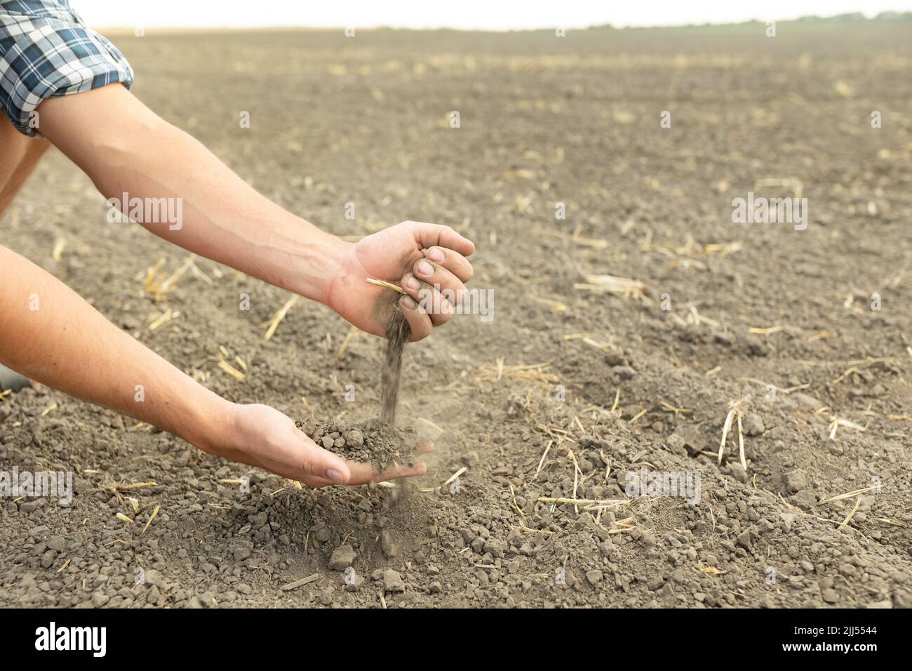 Les mains de l'agriculteur tiennent une poignée de terre fertile et la versent dans l'autre main. Le concept de l'agriculture, de l'agroalimentaire. Le jardinier tient fertil Banque D'Images