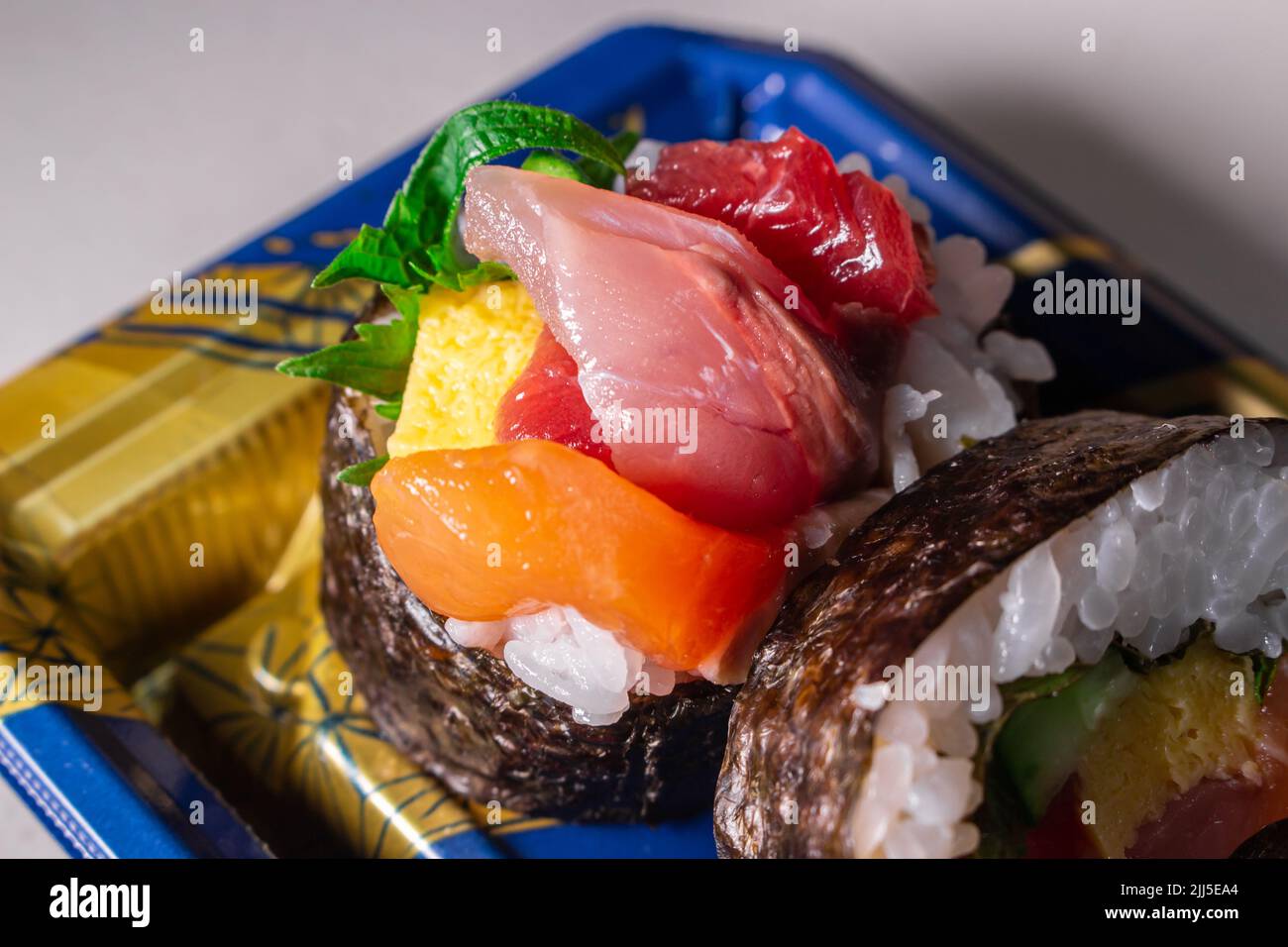 Sortez le Kaisen Maki Zushi dans un plateau alimentaire en plastique Norimaki sur l'image, déployé par la feuille de shiso, le saumon, l'œuf frit (Tamago Yaki), le thon (Maguro) et le concombre Banque D'Images