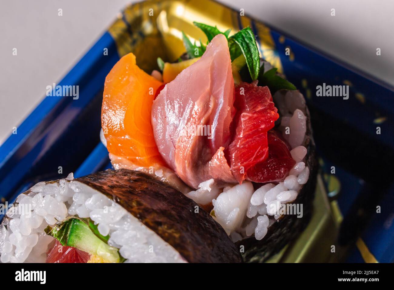 Sortez le Kaisen Maki Zushi dans un plateau alimentaire en plastique Norimaki sur l'image, déployé par la feuille de shiso, le saumon, l'œuf frit (Tamago Yaki), le thon (Maguro) et le concombre Banque D'Images