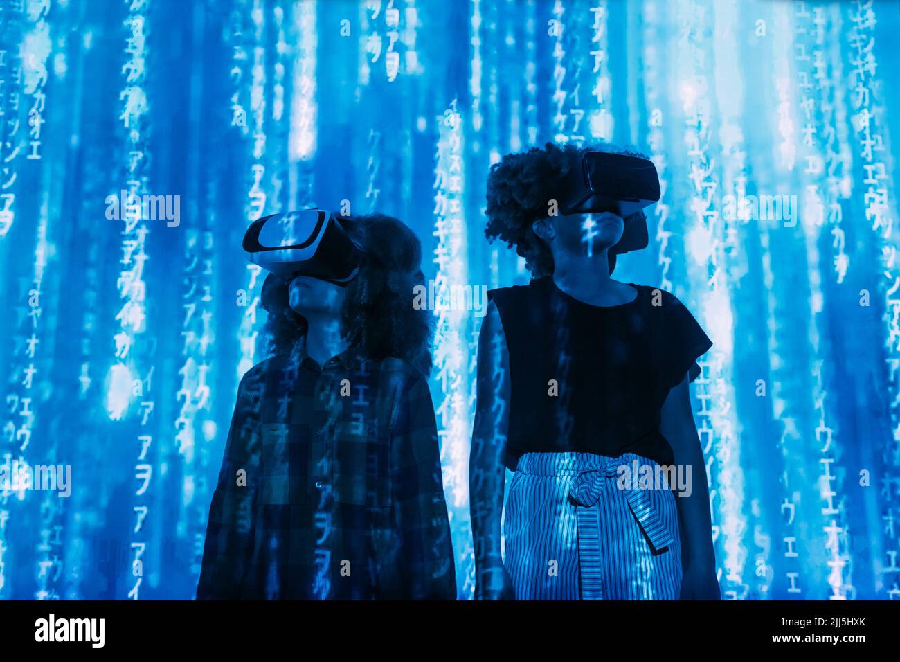 Le code numérique tombe sur garçon et fille portant le simulateur de réalité virtuelle Banque D'Images