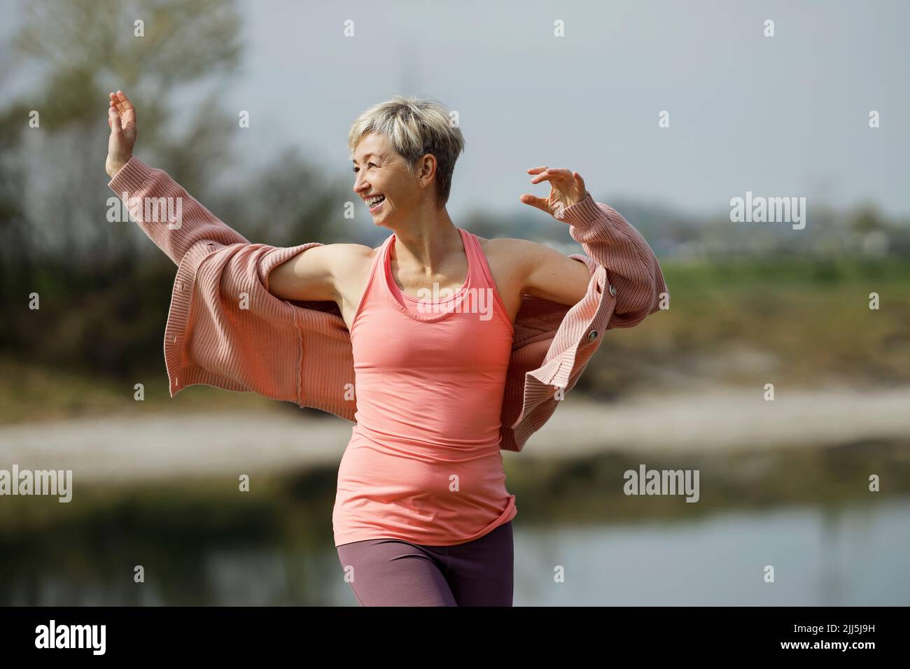 Femme gaie avec des cheveux courts appréciant la journée ensoleillée Banque D'Images