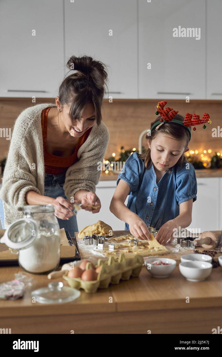 Une mère souriante avec sa fille qui fait des biscuits dans la cuisine Banque D'Images