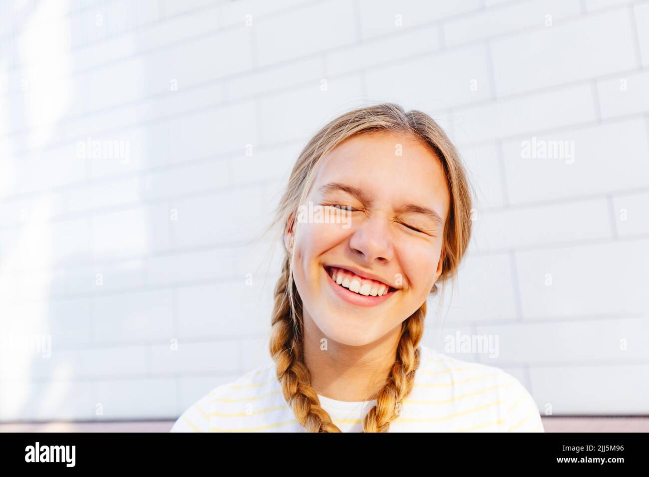 Fille gaie debout devant le mur Banque D'Images