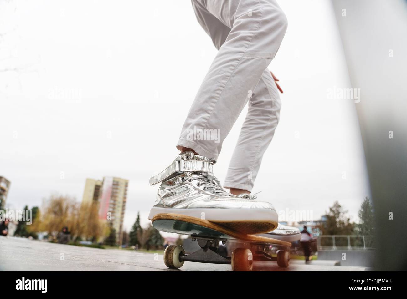 Jambes d'un homme mûr sur un skateboard Banque D'Images