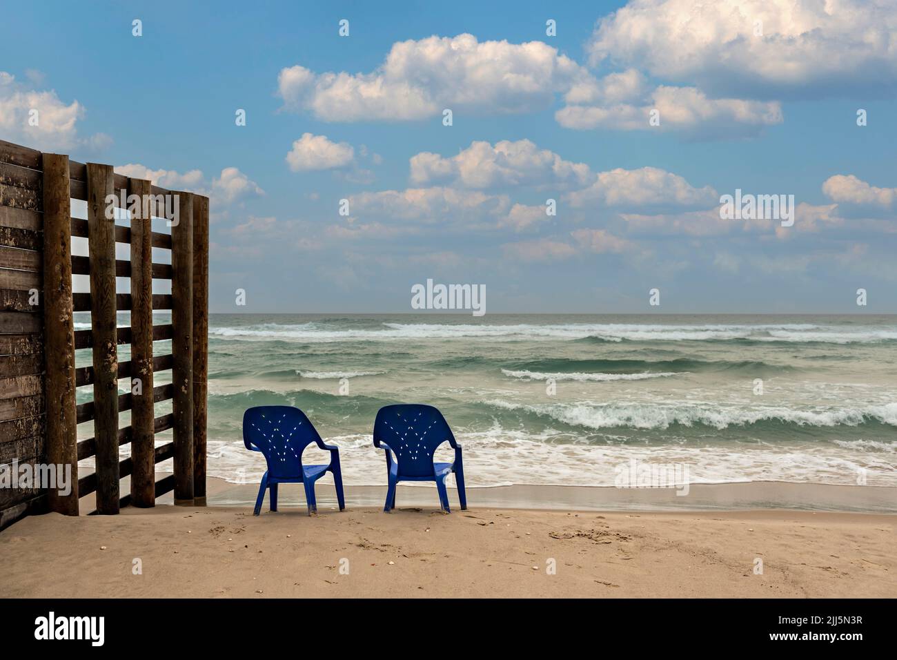 Israël, district de tel Aviv, Bat Yam, deux chaises en plastique laissées sur une plage vide Banque D'Images