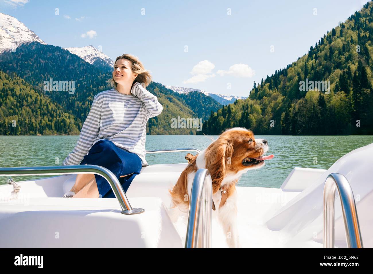 Bonne femme avec un chien en bateau au lac Ritsa Banque D'Images