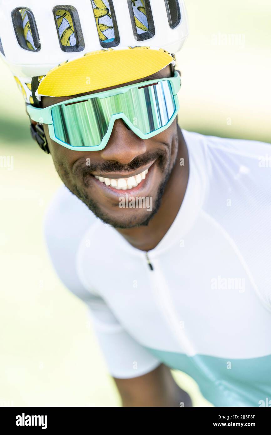 Cycliste heureux portant un casque de cyclisme et des lunettes de soleil Banque D'Images