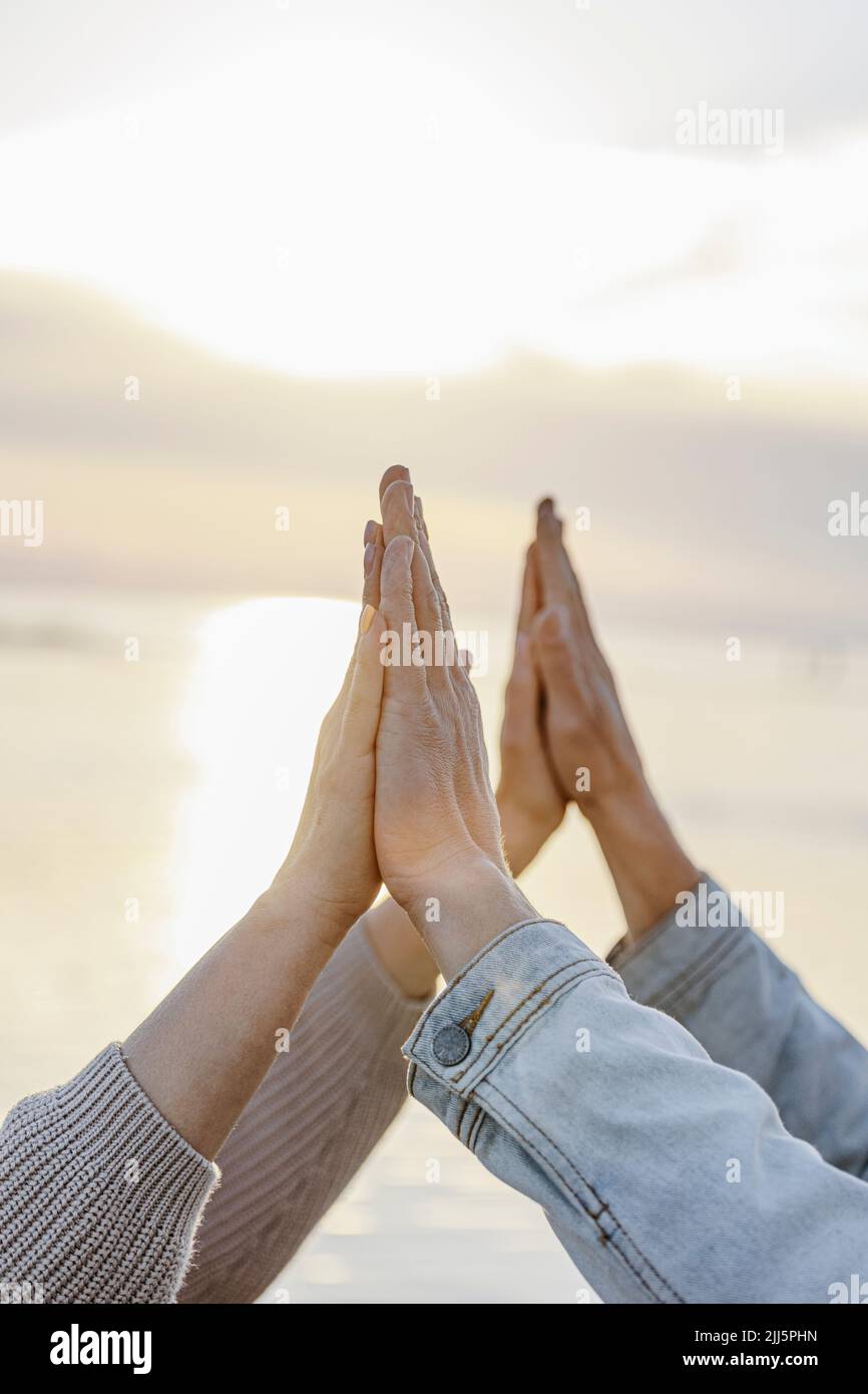 Petite amie et petit ami se touchant les mains au coucher du soleil Banque D'Images