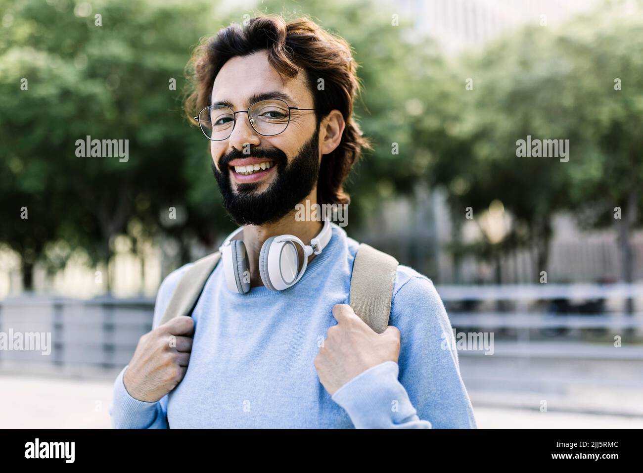 Joyeux barbu avec un casque sans fil Banque D'Images