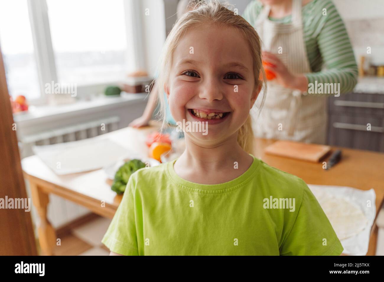 Une fille souriante dans la cuisine à la maison Banque D'Images