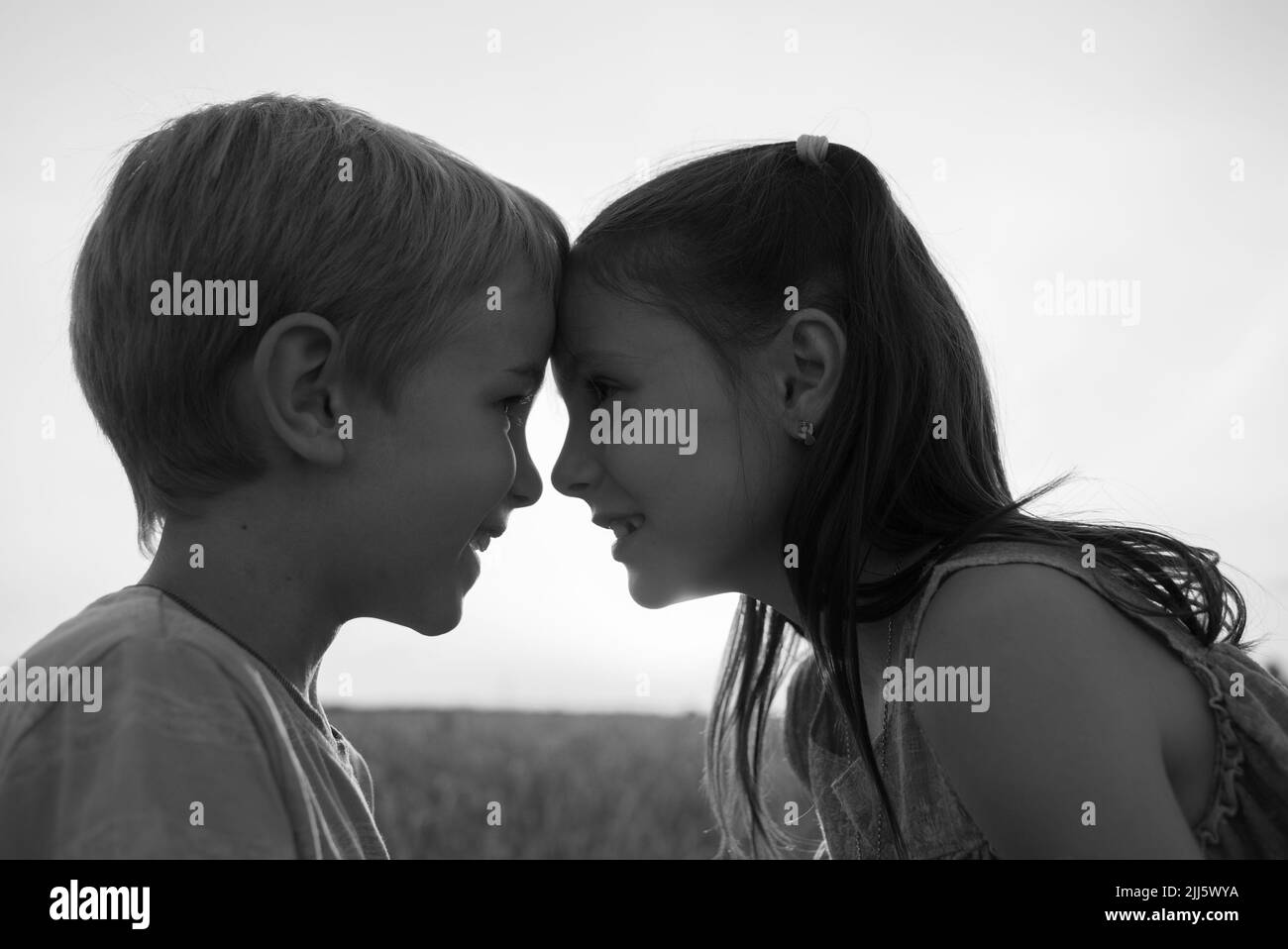 portrait noir et blanc de fille et de garçon , regardant l'un l'autre cutely, appuyant leurs avant-têtes un à un. Famille, amitié, progéniture, enfance Banque D'Images