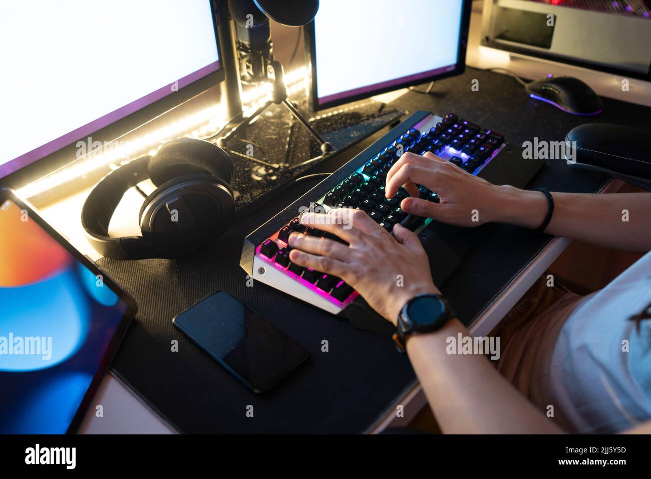 Homme tapant sur le clavier assis devant l'ordinateur de bureau Banque D'Images