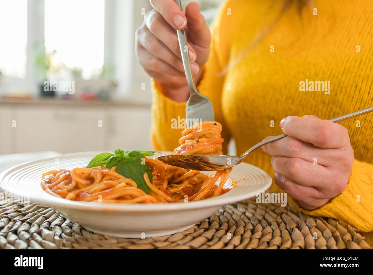 Mains de femme tenant la fourchette avec spaghetti à la maison Banque D'Images