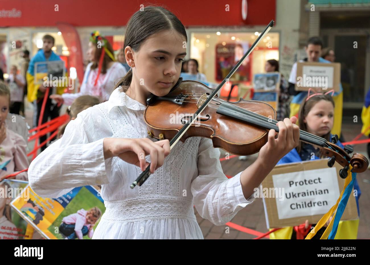 ALLEMAGNE, Hambourg, action contre la guerre de Putins en Ukraine et pour les enfants ukrainiens souffrant dans la guerre / DEUTSCHLAND, Hambourg, Fußgängerzone Ottensen, Aktion gegen Putins Krieg in der Ukraine und für die leidenden ukrainischen Kinder im Krieg, Ukrainisches Mädchen spielt auf der Violine ein Lied für die gefallenen Soldaten in der Ukraine Banque D'Images