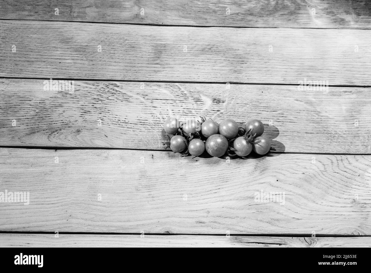 Tomates cerises fraîches sur une planche de bois. Banque D'Images