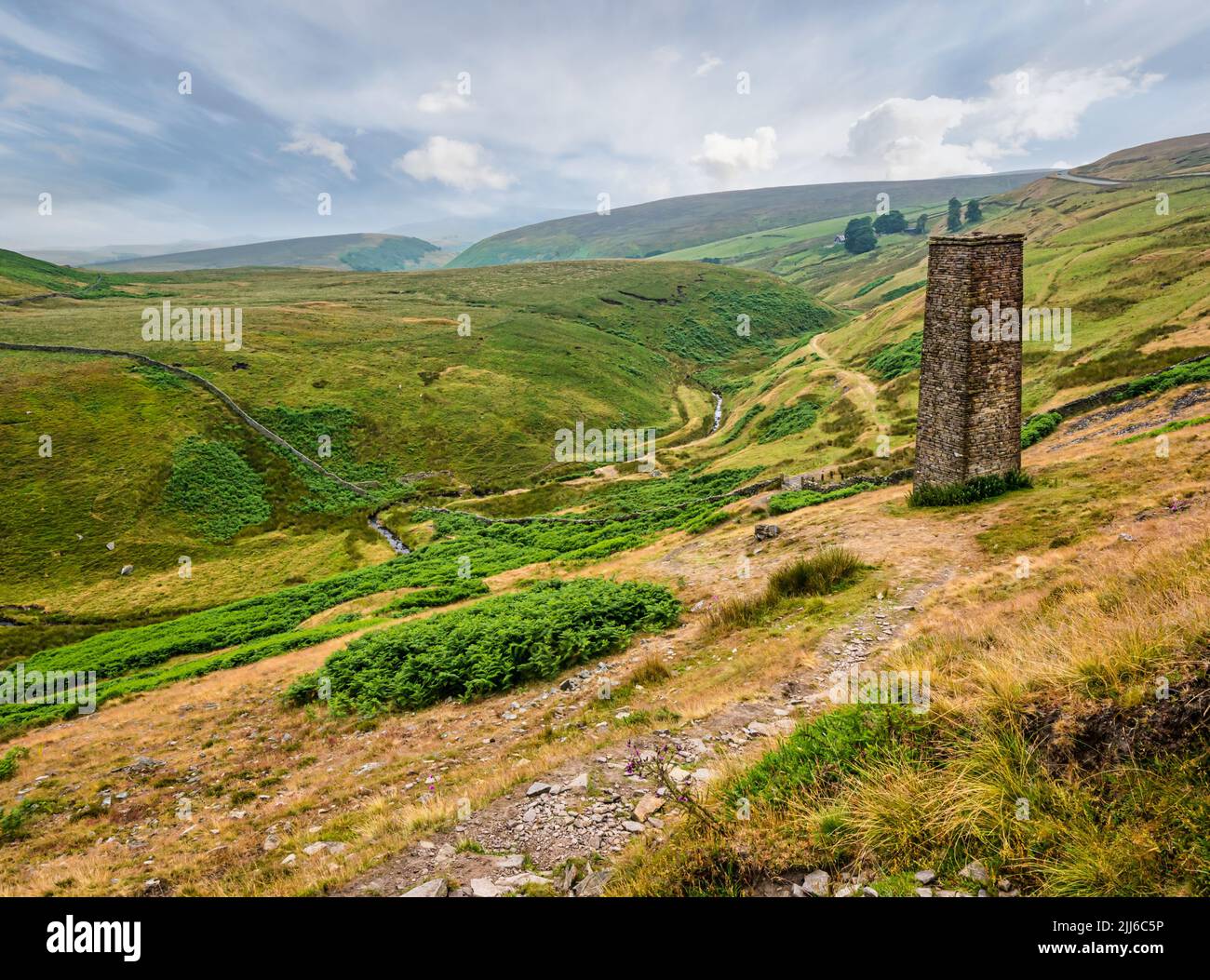 Ancienne tour de ventilation de mine de pierre surplombant la vallée dans un paysage sombre, Peak District, Angleterre, Royaume-Uni Banque D'Images