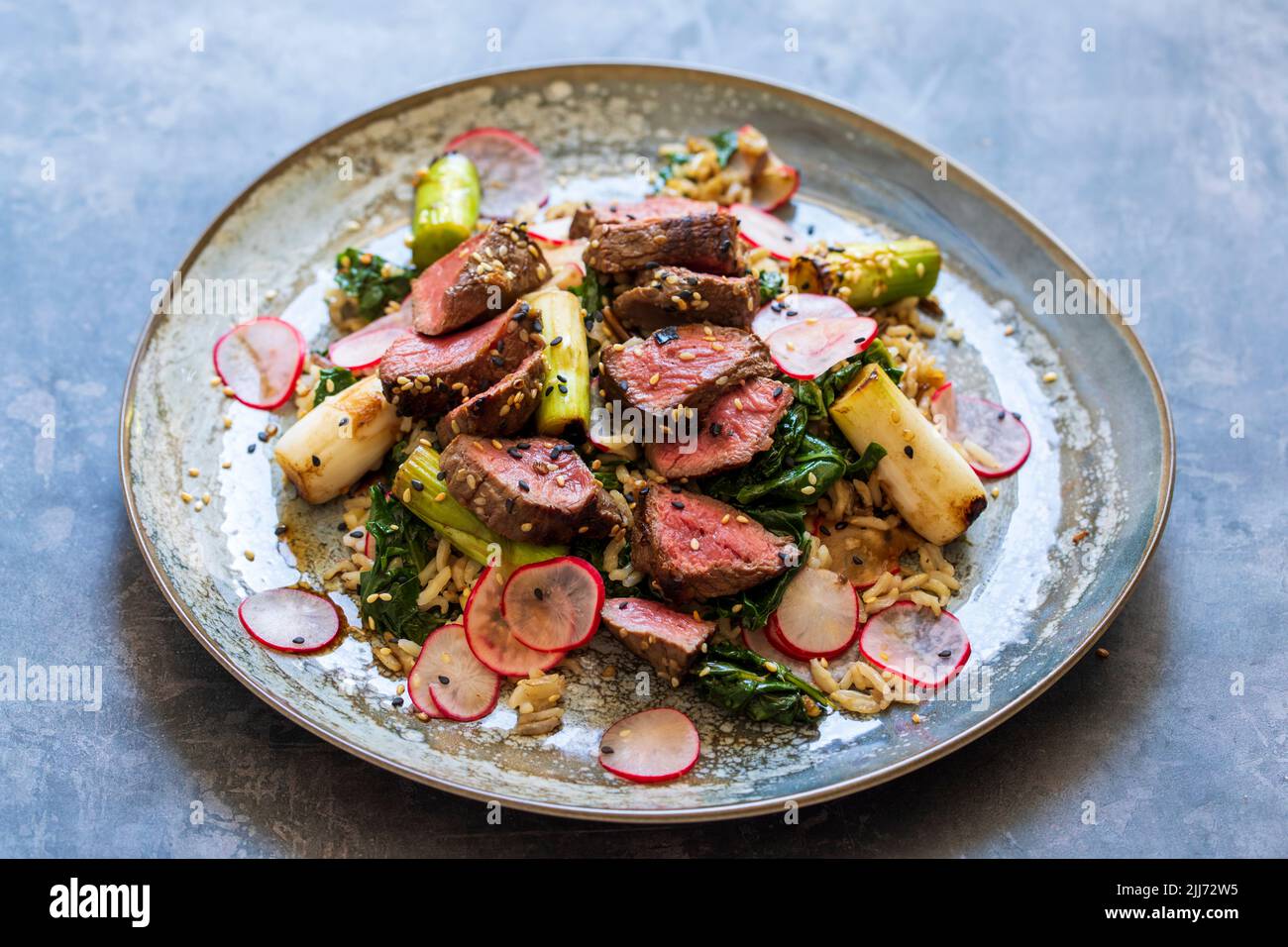 Steak de bœuf avec riz, chou frisé et radis Banque D'Images