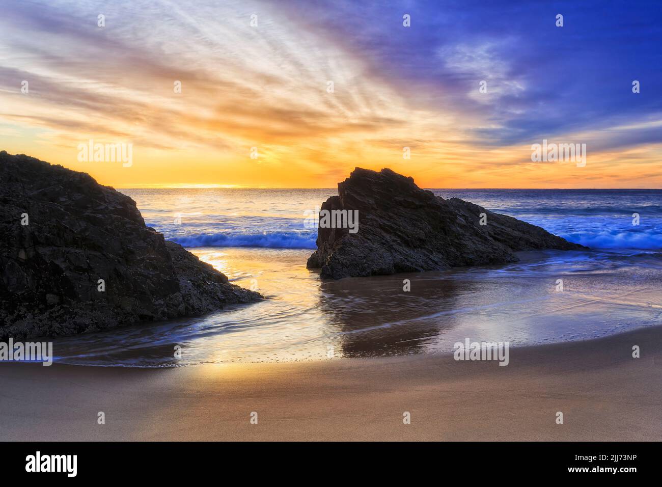 Des rochers pittoresques sur la plage de Burgess dans la ville de Forster, en Australie, sur la côte du Pacifique, à un lever de soleil coloré. Banque D'Images