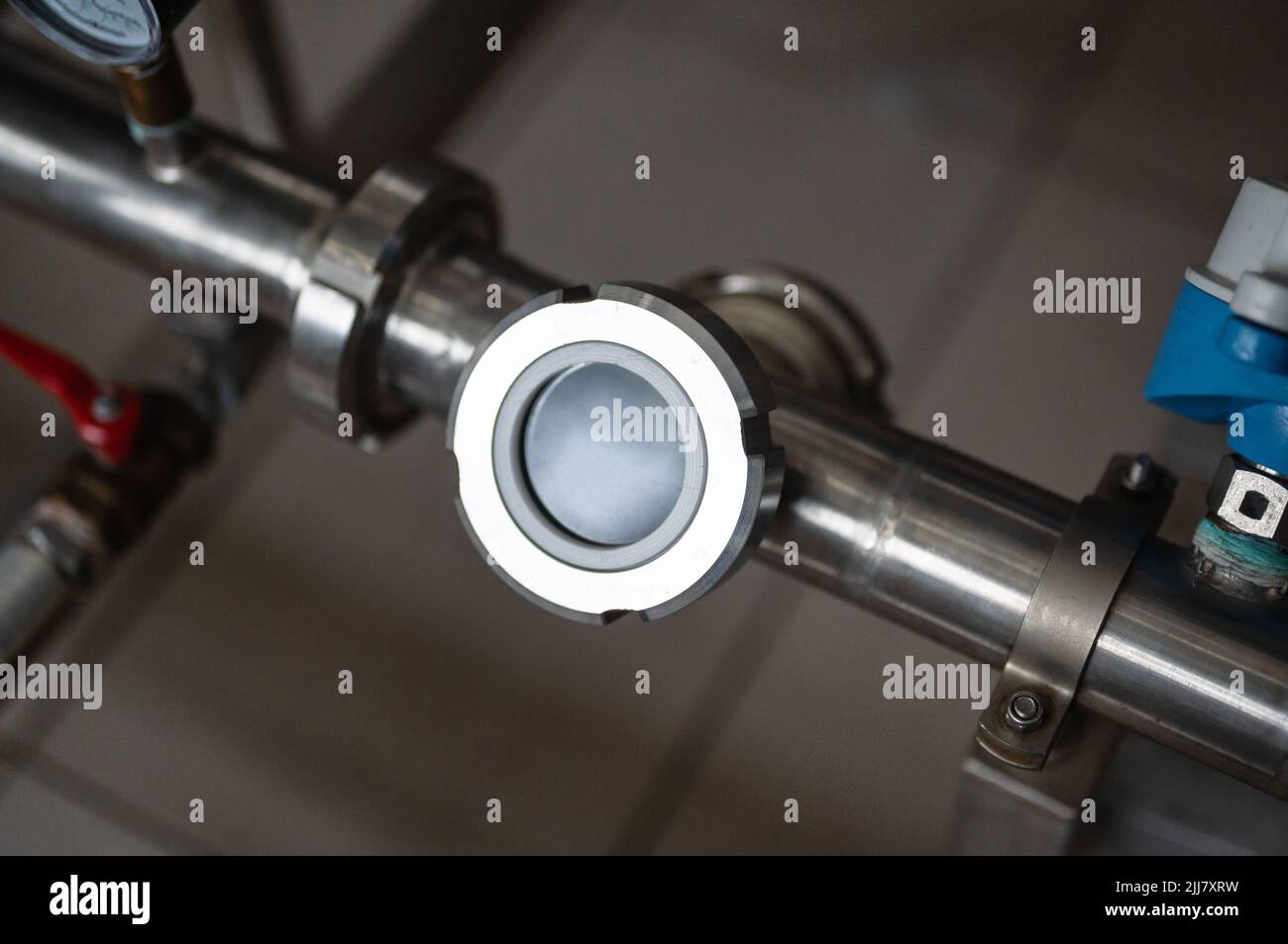 Compteur de liquide sur tuyauterie en métal gris avec brides à l'usine Banque D'Images