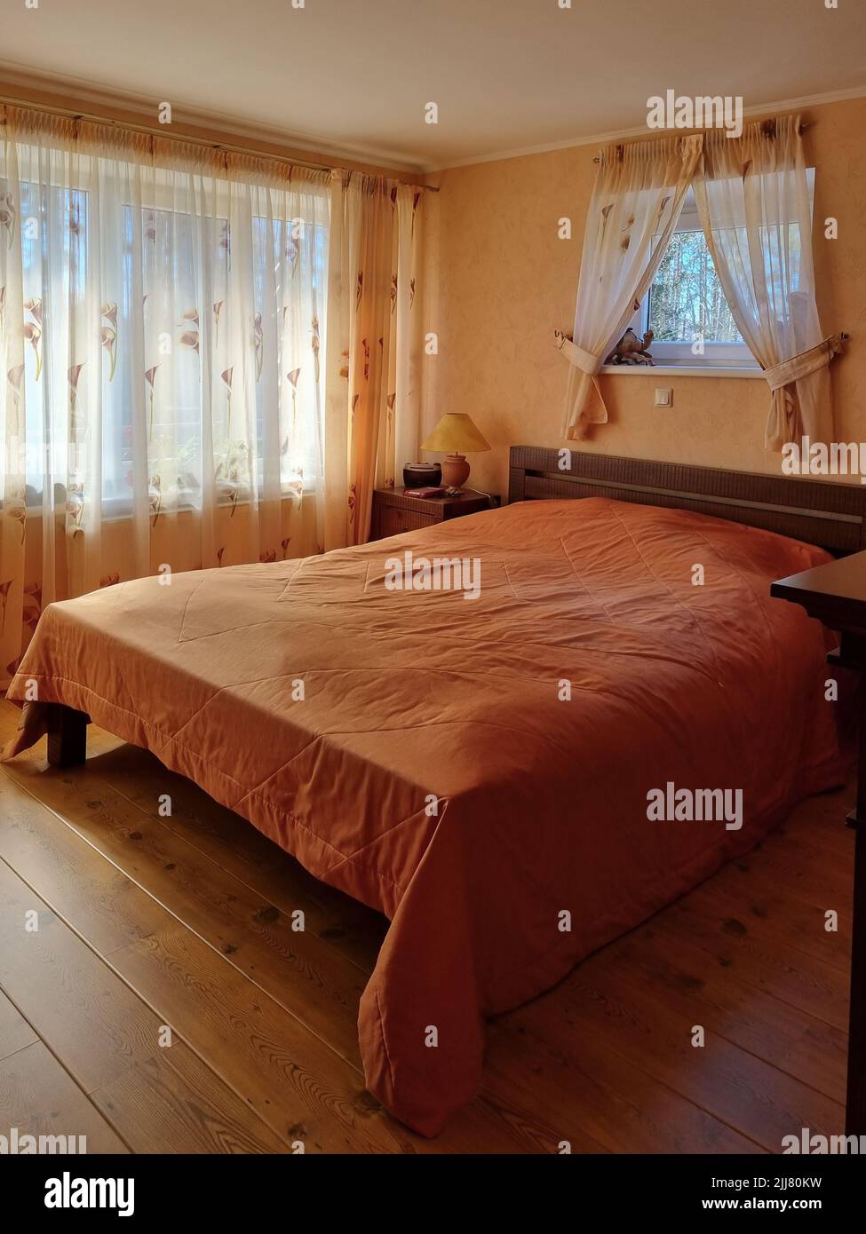 Petite chambre confortable à la maison de campagne. Intérieur rural dans la palette de couleurs chaudes. Chambre rétro avec parquet. Banque D'Images