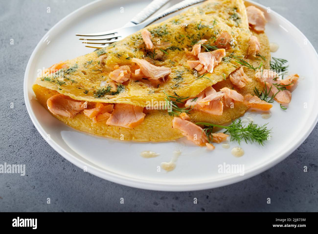 Grand angle d'omelette délicieuse avec saumon et herbes servi sur la table pour le petit déjeuner Banque D'Images