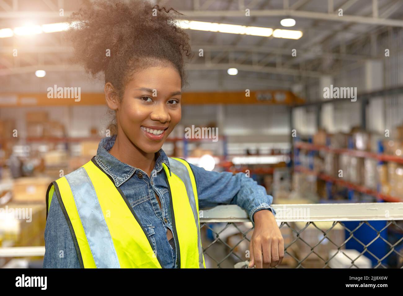 Portrait jeune ado africaine fille noire adolescent travail dans grand entrepôt usine stock heureux sourire. Banque D'Images