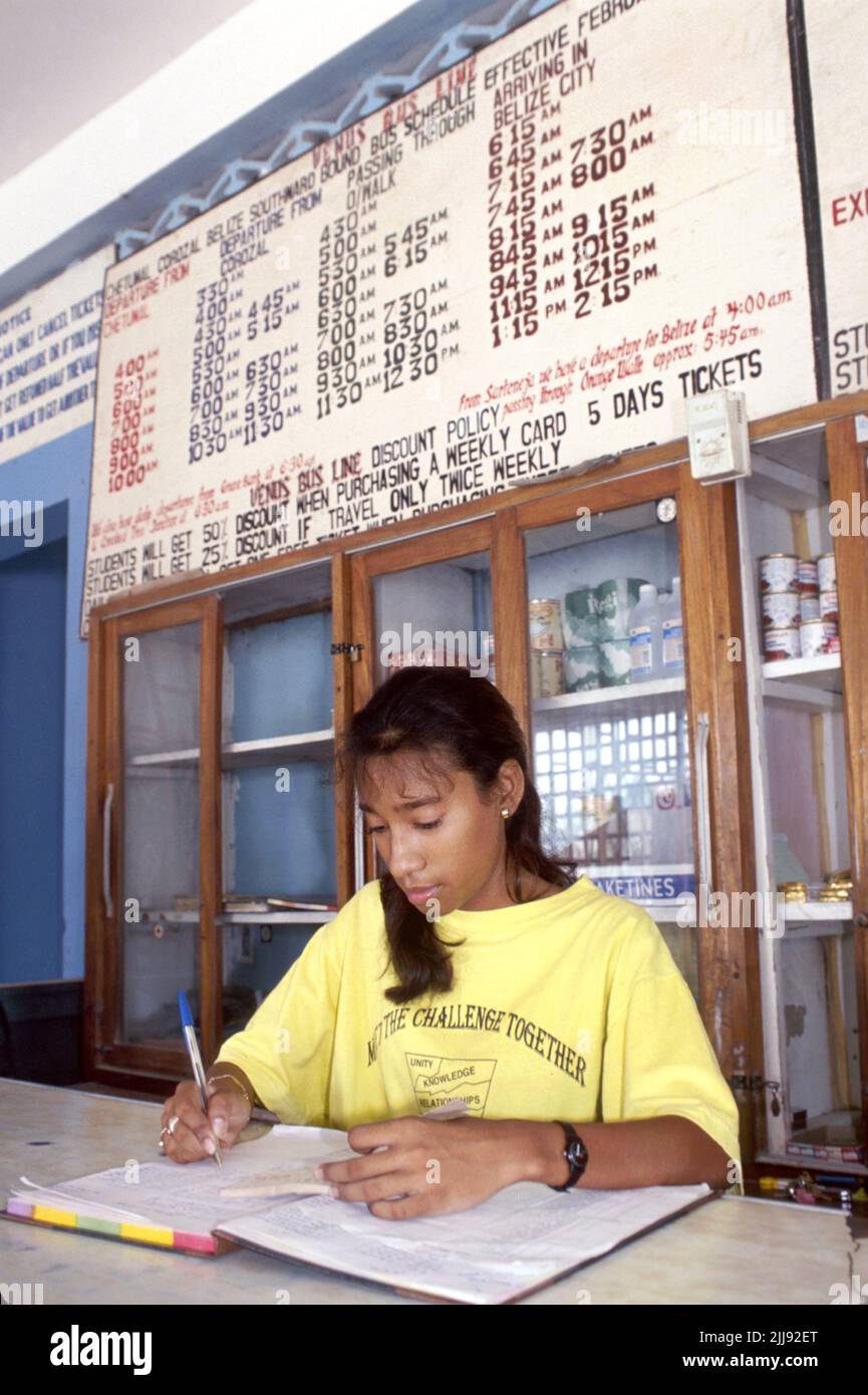 Corozal Belize, service d'autobus public de la station de transport à l'intérieur du comptoir intérieur femme, adolescent adolescent employé horaire des frais généraux Banque D'Images