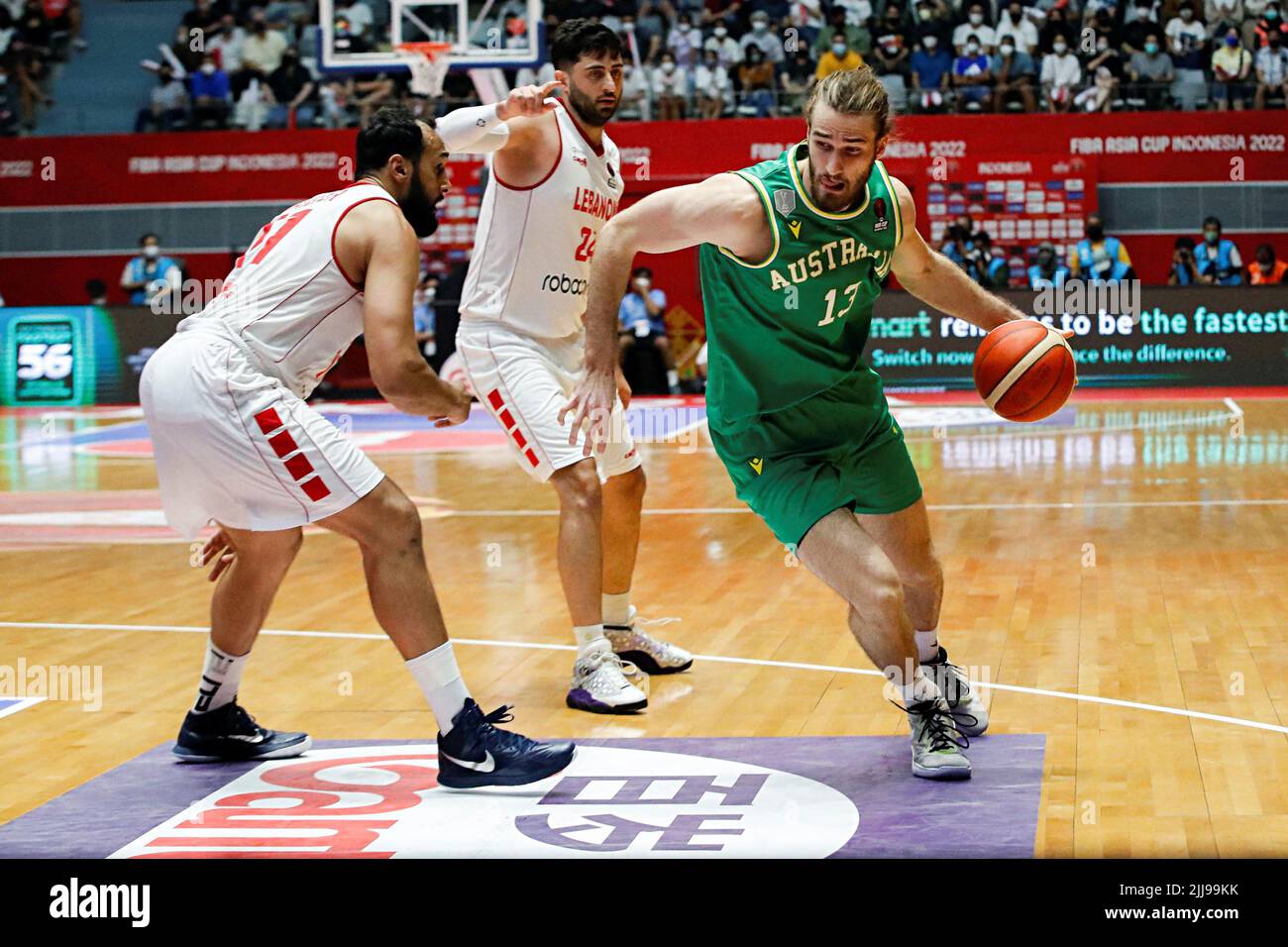 Samson James Froling, de l'Australie, fait des dribbles contre Hayk  Gyokchyan et Ali Haidar, du Liban, lors du match final de la coupe d'Asie  du basket-ball 2022 de la FIBA entre le