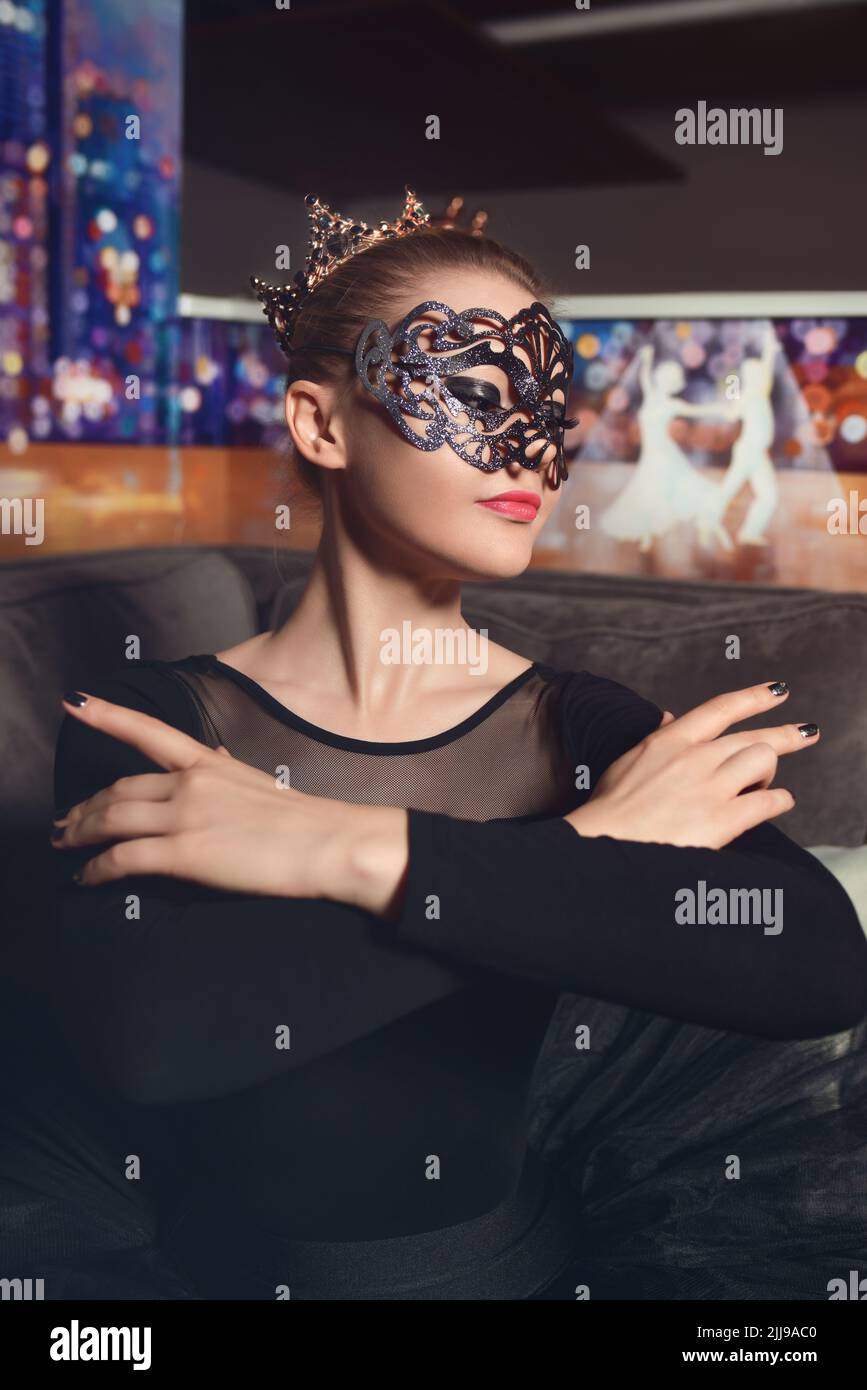 Portrait d'une belle ballerine modèle portant une couronne et un masque de carnaval dans un tutu noir dans le studio. Ballerine de cygne noir Banque D'Images