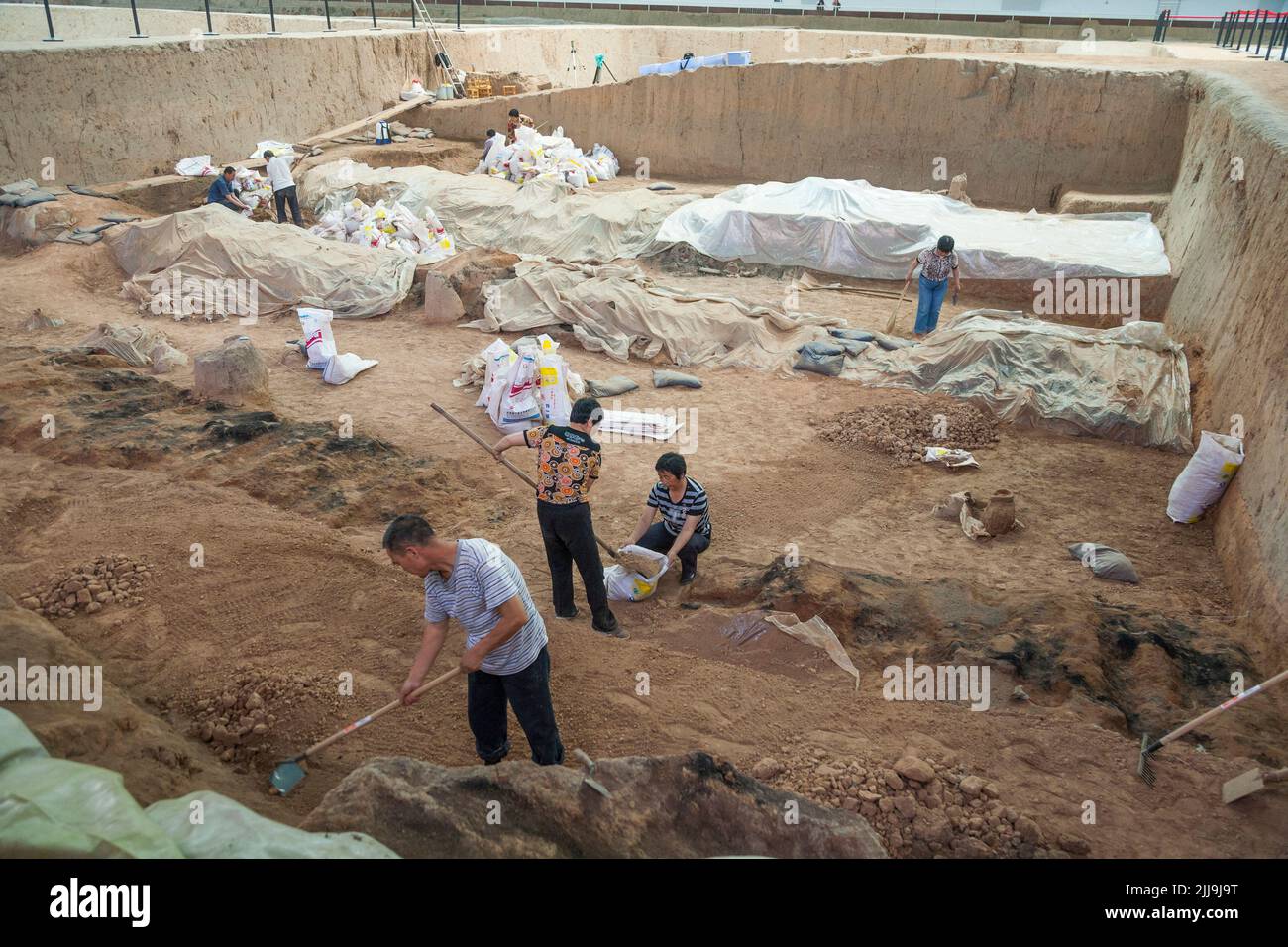 Fouilles archéologiques. Les archéologues retirent soigneusement les débris autour des objets enterrés découverts dans la fosse 1 à l'excavation de l'armée de terre cuite, au musée du Mausolée de l'empereur Qinshihuang à Xi'an, en Chine. PRC. (125). Banque D'Images