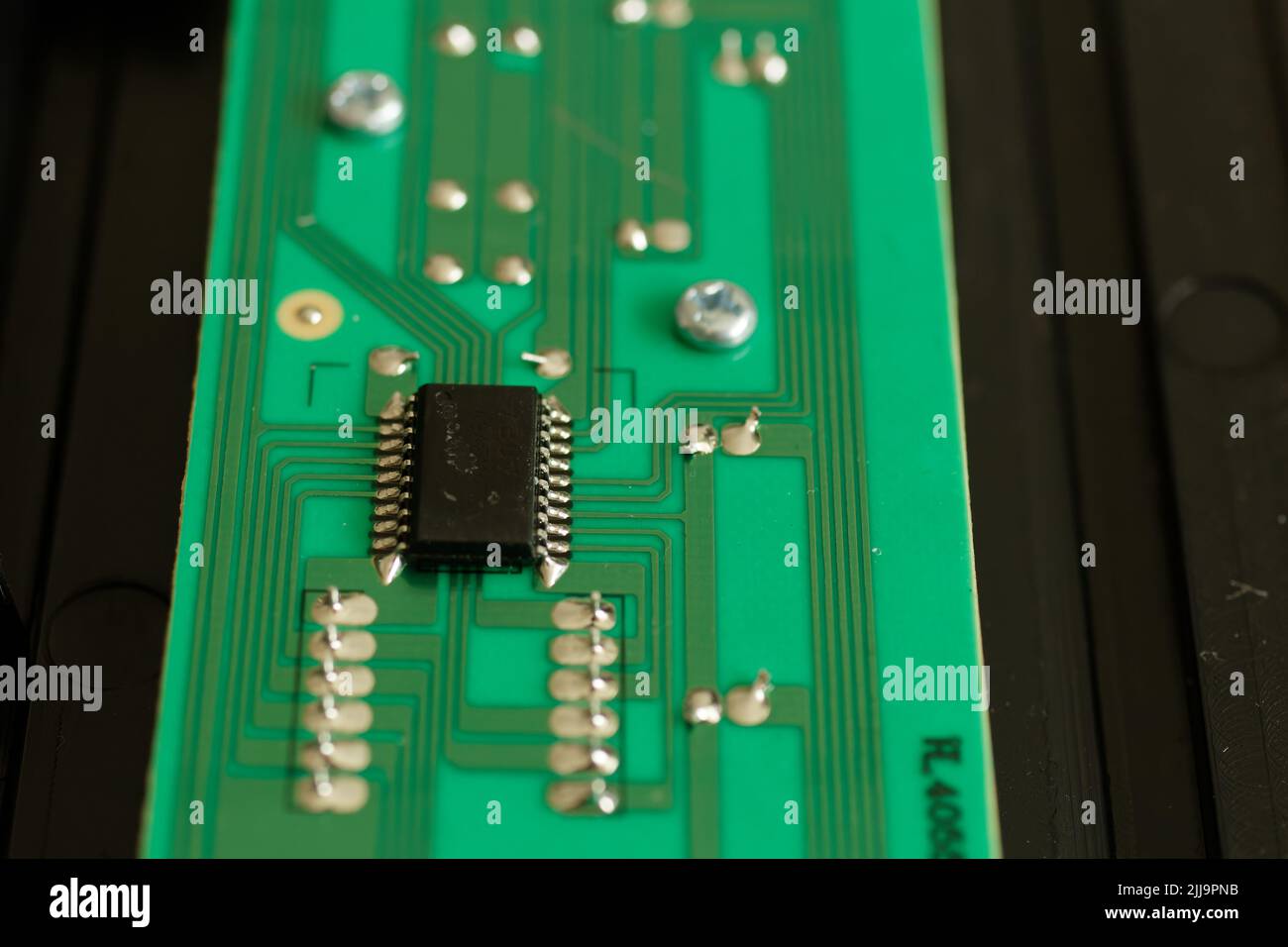 Gros plan d'un composant électronique sur une carte de circuit imprimé verte avec bokeh profond Banque D'Images