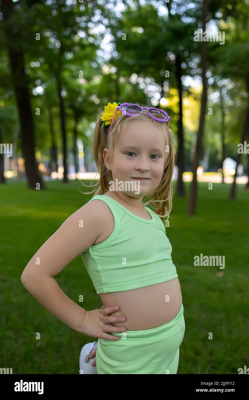 petite fille modèle posant dans le parc dans un costume vert Banque D'Images