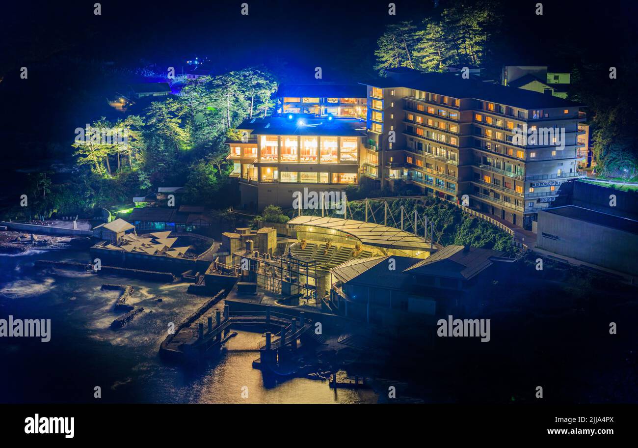 La nuit, les lumières de l'hôtel côtier onsen illuminent la brume marine Banque D'Images