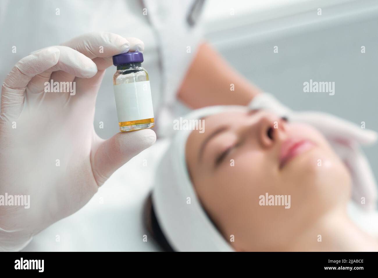 Une femme tient un produit cosmétique dans sa main. Solution injectable. Banque D'Images