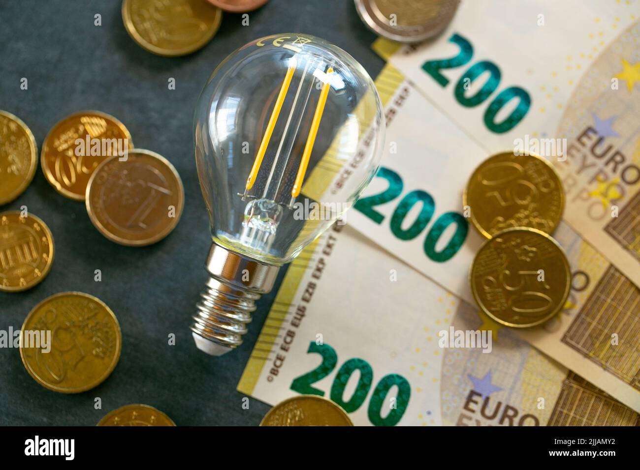 Hausse des prix de l'électricité en Europe.ampoule, billets et pièces de monnaie sur le tableau de craie.augmentation du coût de la lumière et de la chaleur.économie d'électricité.crise de Banque D'Images