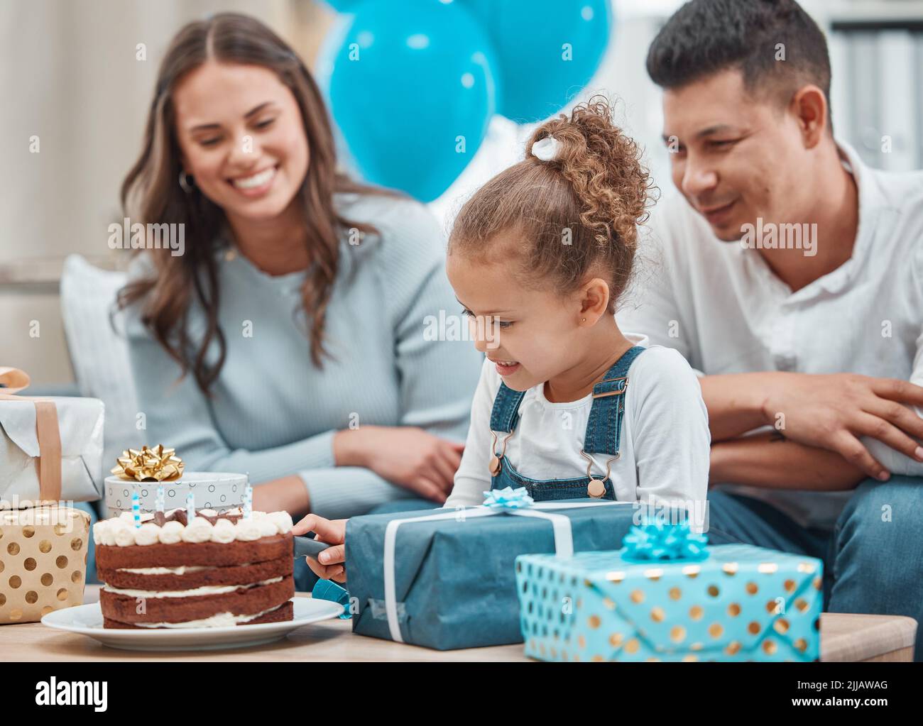 Ayez votre gâteau et partagez-le aussi. Une famille heureuse célébrant un anniversaire à la maison. Banque D'Images