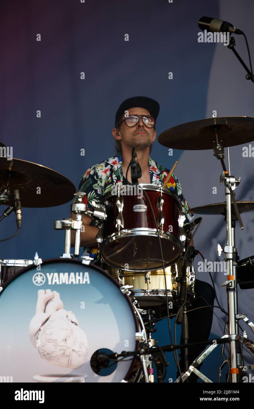 Josh Trager joue des tambours sur scène portant une chemise hawaïenne, des lunettes de soleil et une casquette de baseball Banque D'Images