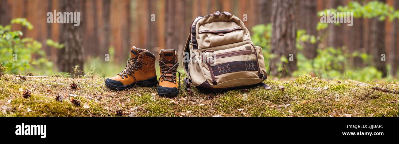 Matériel de randonnée en forêt. Sac à dos et bottines en cuir. Vue panoramique avec espace de copie Banque D'Images