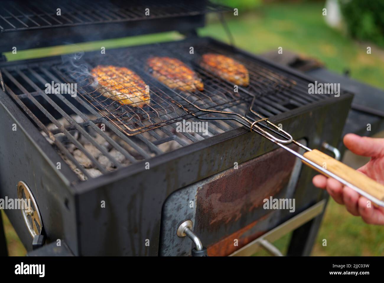 les steaks de saumon sur le grill sont cokking sur le bois de chauffage dans l'arrière-cour. Banque D'Images