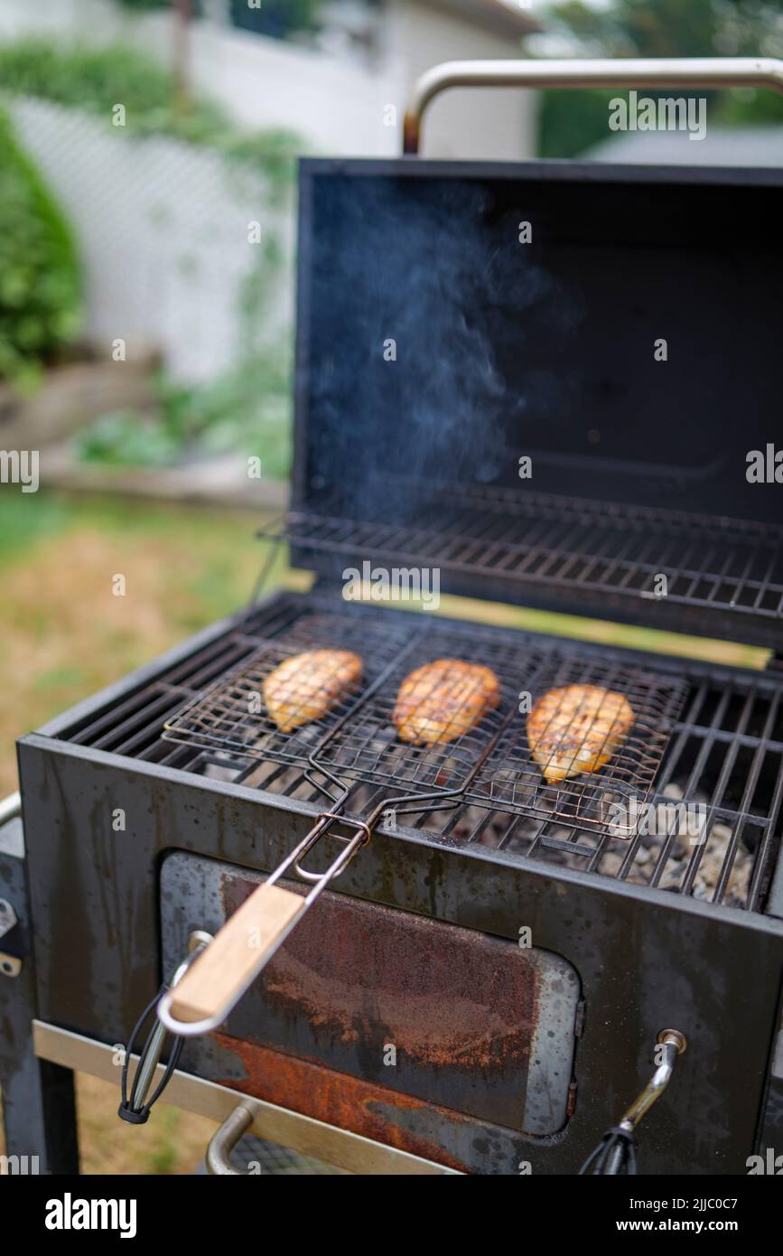 les steaks de saumon sur le grill sont cokking sur le bois de chauffage dans l'arrière-cour. Banque D'Images