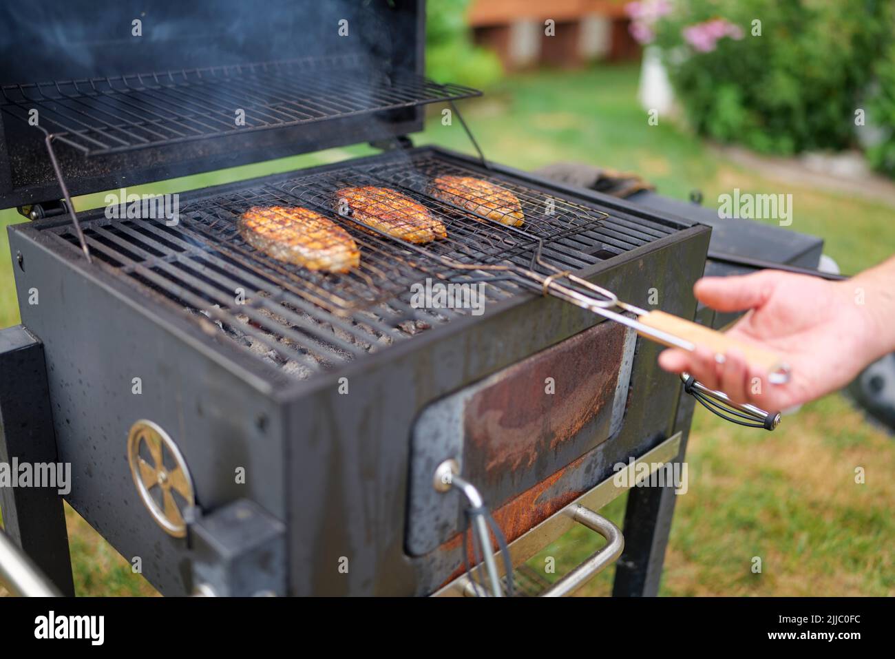 les steaks de saumon sur le grill sont cokking sur le bois de chauffage dans l'arrière-cour. Banque D'Images