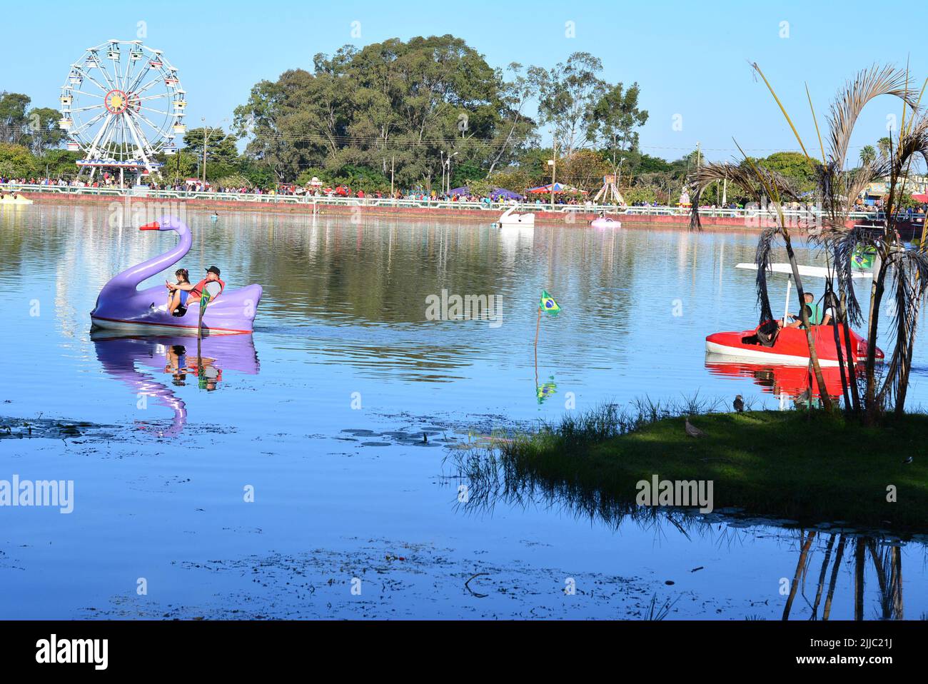 Pédalo ou aviron sur le lac à Lago avec grande roue en arrière-plan avec drapeaux brésiliens, panoramique, sélectif foyer Banque D'Images