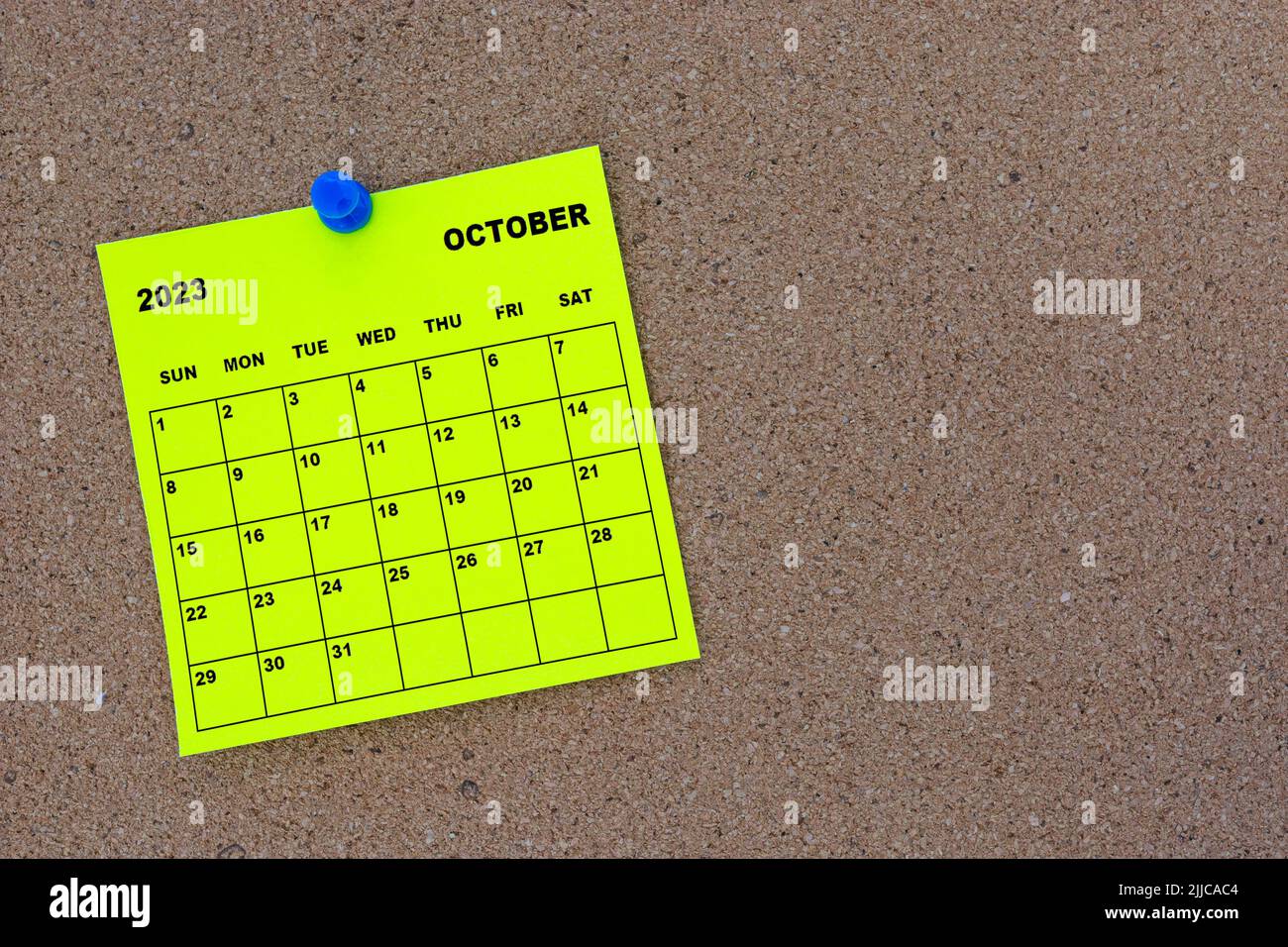 Octobre 2023 calendrier de notes adhésives jaunes avec épinglette sur le panneau d'affichage en liège. Banque D'Images