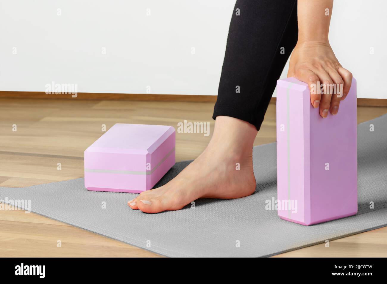 Femme entraînement de yoga avec blocs de yoga sur tapis de yoga à l'intérieur. Un mode de vie sain. Banque D'Images