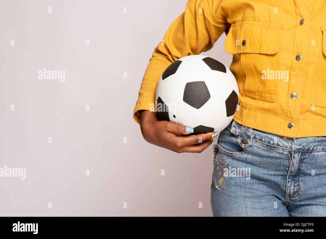 femme noire portant un ballon de football Banque D'Images
