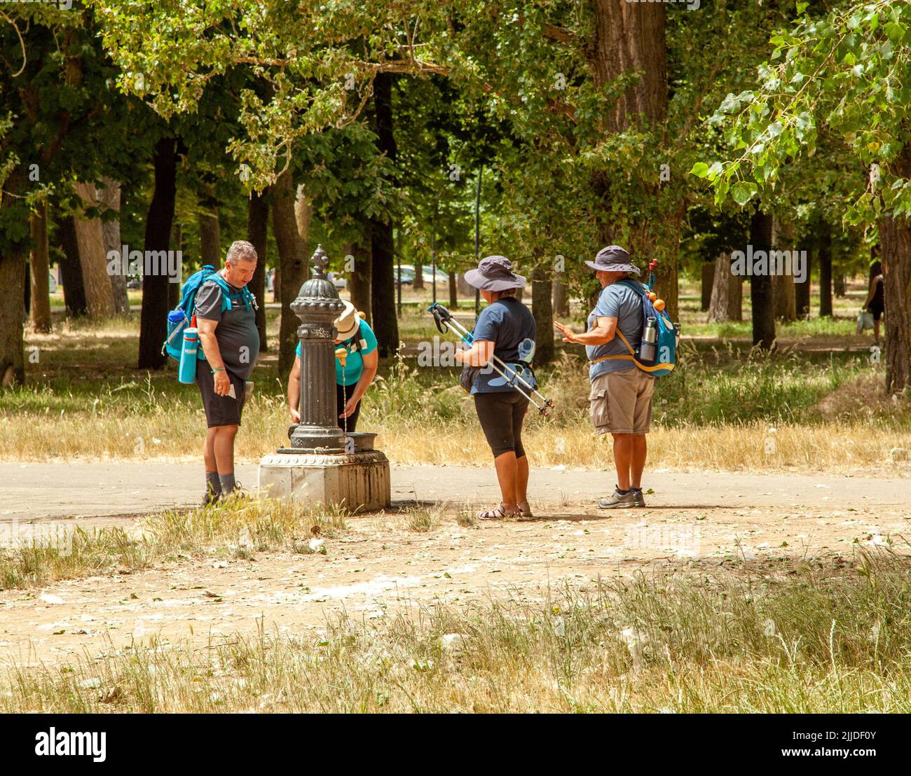 Les pèlerins marchant dans le Camino de Santiago le chemin du pèlerinage de St James prenant un verre d'une fontaine en marchant dans Burgos Espagne Banque D'Images