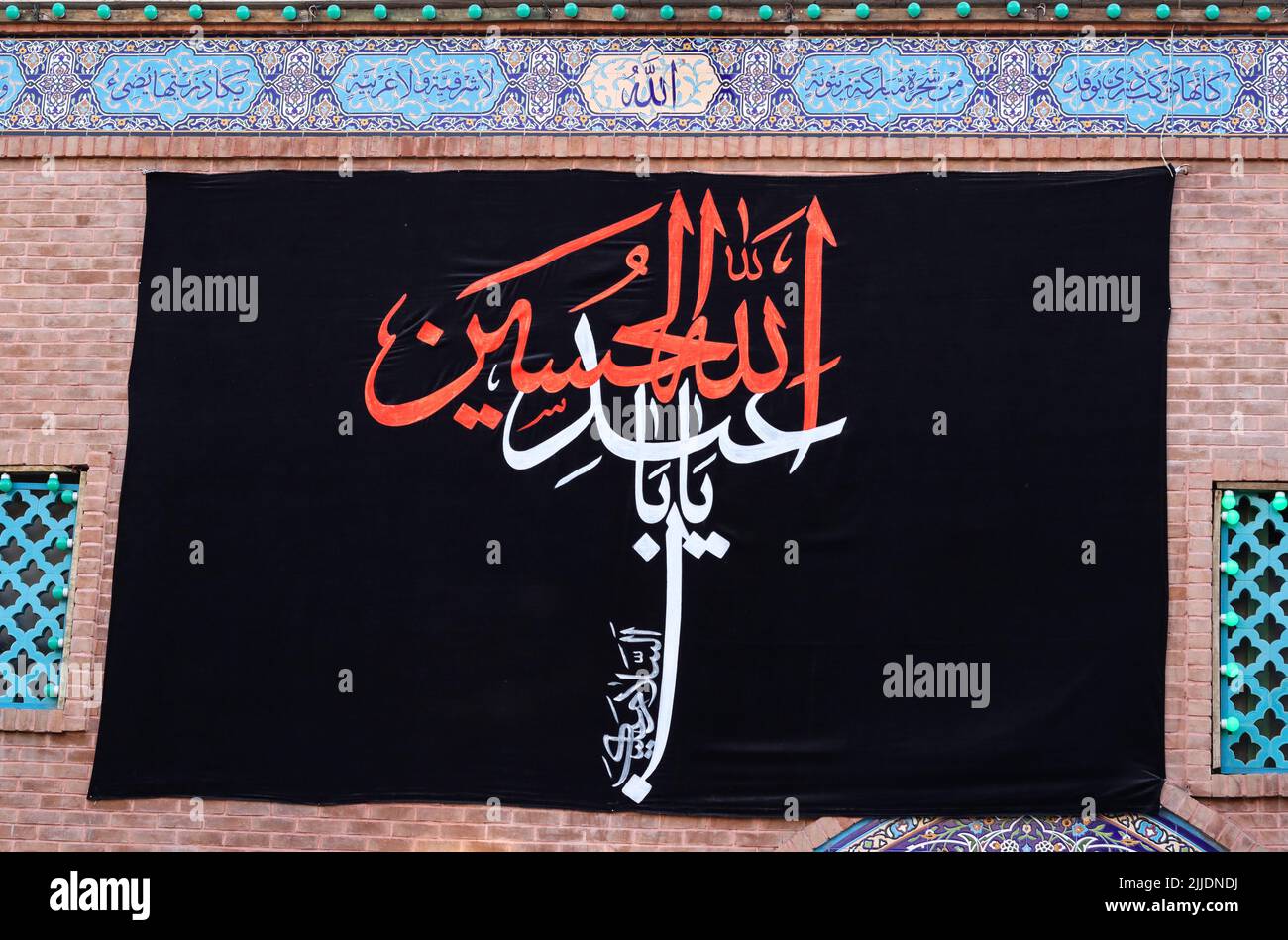 Drapeau de deuil de l'Imam Hossein sur le mur de la mosquée Banque D'Images