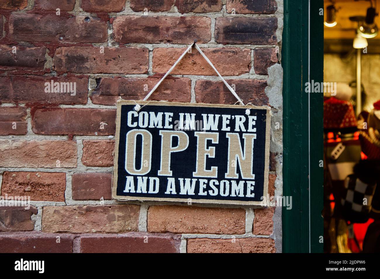 « Venez, nous sommes ouverts et impressionnants. » Un panneau ludique invite les clients dans un magasin. Banque D'Images