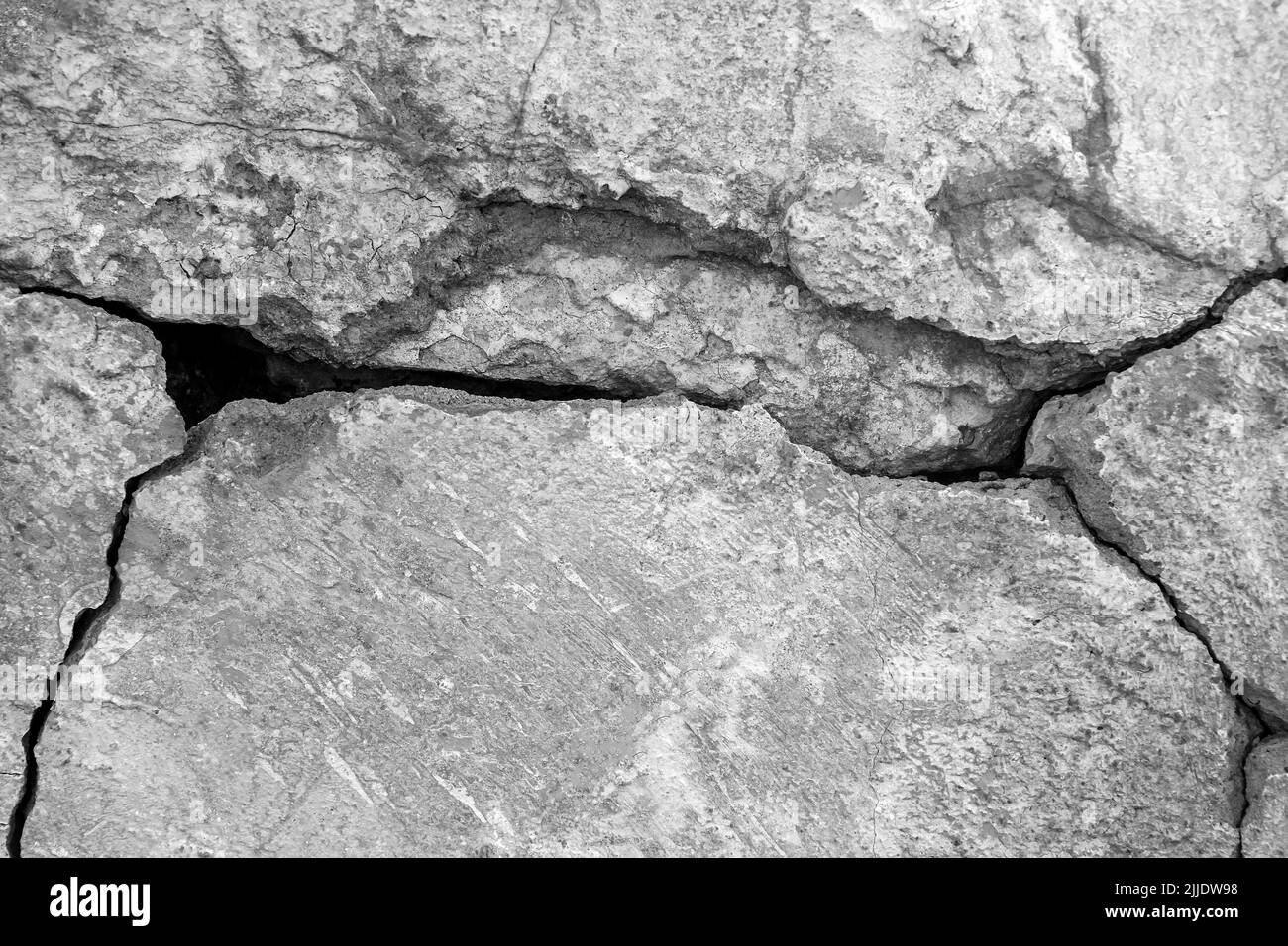Grande fissure profonde sur l'ancien mur en plâtre. Restes de plâtre. Nombreuses couches de peinture. Photo en noir et blanc. Copier l'espace. Gros plan. Foc sélectif Banque D'Images