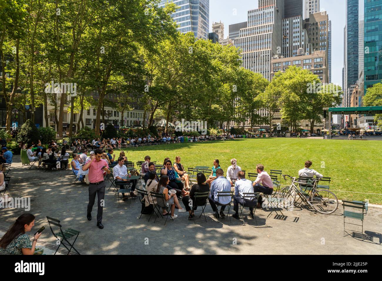 Les visiteurs du Bryant Park à New York cuisent au soleil ou cherchent l'ombre le mardi, 19 juillet 2022. Aujourd'hui est le premier jour de la vague de chaleur prévue qui est promis par les intempéries de durer au moins pour les six prochains jours. (© Richard B. Levine) Banque D'Images